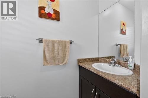 Built-in vanity with a white oval sink, chrome faucet, and integrated countertop - 88 Highgate Drive, Hamilton, ON 