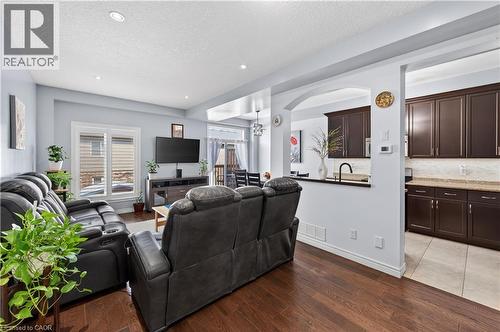 Hardwood-finish flooring, recessed lighting, and a kitchen with dark cabinetry, light countertops, and a tile backsplash - 88 Highgate Drive, Hamilton, ON 