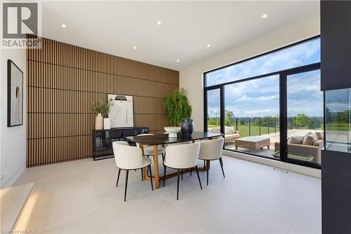 Wood-panel accent wall, recessed lighting, expansive floor-to-ceiling windows, and light-toned tile flooring - 5709 Forth Line, Hillsburg, ON 