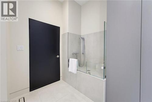 Contemporary bathroom featuring a bathtub with a partial glass enclosure, tile surround, and a handheld shower fixture - 5709 Forth Line, Hillsburg, ON 
