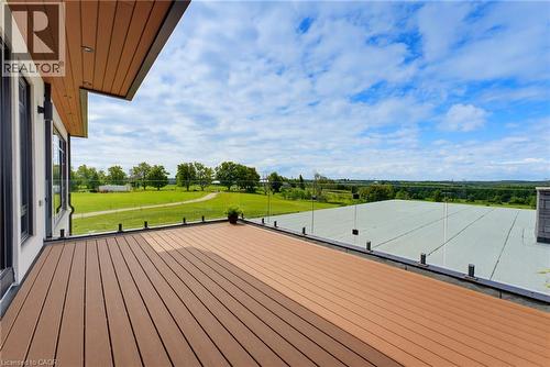 Expansive outdoor deck featuring composite decking, glass railing, and attached exterior lighting - 5709 Forth Line, Hillsburg, ON 