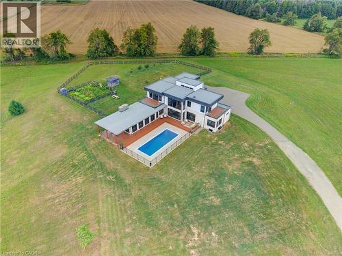 Contemporary architecture with multiple rooflines, an in-ground swimming pool, an expansive deck, a private driveway, and an enclosed garden area - 5709 Forth Line, Hillsburg, ON 