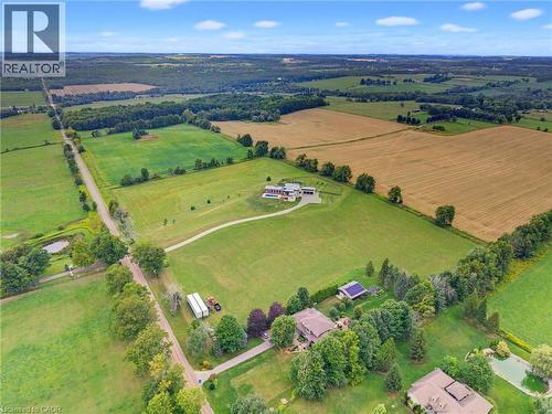 Sprawling rural landscape featuring vast agricultural fields, established tree lines, and multiple residential properties - 5709 Forth Line, Hillsburg, ON 