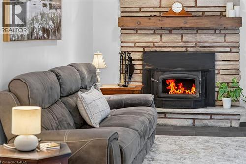 Living room with wood burning fireplace and walkout to rear deck and yard. - 2023 Latimer Crescent, Greater Sudbury, ON 