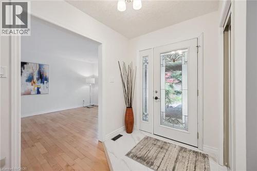 Entryway featuring a white door with decorative glass inserts, a white side panel with decorative glass, and a white ceiling light fixture - 345 Beechlawn Drive, Waterloo, ON 