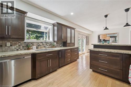 Kitchen featuring dark wood cabinetry, light wood-finish flooring, and light granite countertops - 345 Beechlawn Drive, Waterloo, ON 