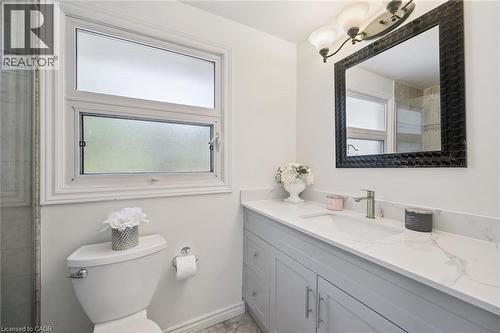 Bathroom featuring a single vanity with a solid surface countertop, an integrated sink, and brushed nickel fixtures - 345 Beechlawn Drive, Waterloo, ON 