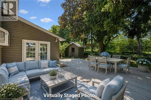 Expansive outdoor deck featuring wood-finish flooring, direct access via patio doors, and a detached shed - 345 Beechlawn Drive, Waterloo, ON 