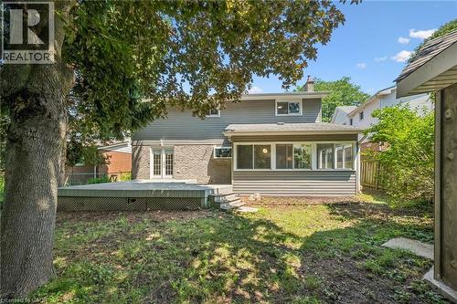 Rear exterior featuring a sunroom, a multi-level deck, and double French doors - 345 Beechlawn Drive, Waterloo, ON 