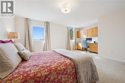 Carpeted flooring, built-in desk, built-in cabinetry, dual windows, and a semi-flush mount ceiling fixture - 151 Clairfields Drive Unit# 3, Guelph, ON 