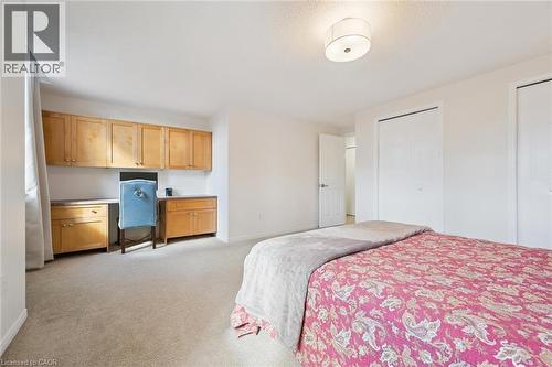 Built-in desk with wood-finish cabinetry, two wardrobe closets, and a semi-flush mount ceiling light - 151 Clairfields Drive Unit# 3, Guelph, ON 