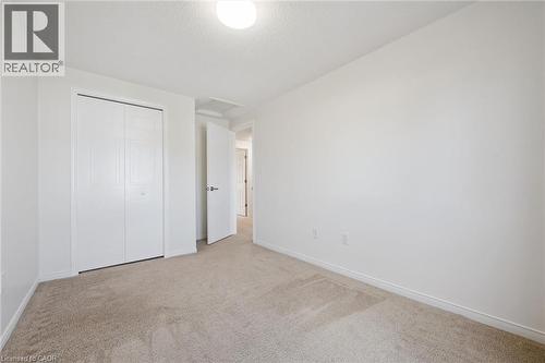 Neutral tone wall finishes, carpeting, flush mount ceiling light fixture, and bifold closet doors - 151 Clairfields Drive Unit# 3, Guelph, ON 
