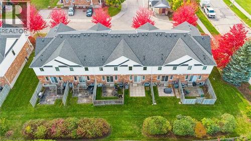 Multi-unit dwelling featuring individual patios, green spaces, and a shingled roof - 151 Clairfields Drive Unit# 3, Guelph, ON 