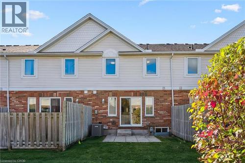Rear exterior with brick and siding facade, patio, and fenced yard - 151 Clairfields Drive Unit# 3, Guelph, ON 