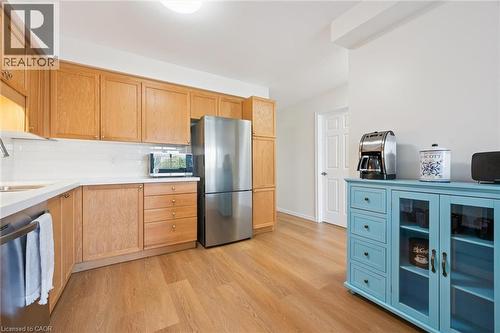 Wood-finish flooring, light wood cabinetry, white subway tile backsplash, white countertops, and stainless steel appliances - 151 Clairfields Drive Unit# 3, Guelph, ON 