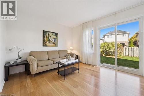 Hardwood-style flooring throughout, with a large sliding glass door opening to a private green space - 151 Clairfields Drive Unit# 3, Guelph, ON 