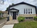 Modern brick and siding exterior featuring a peaked roofline, black-trimmed entry vestibule with paneled door, and expansive front-facing multi-pane window - 99 Cluthe Crescent, Kitchener, ON 