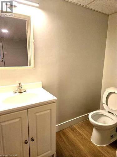 White vanity with integrated sink, chrome faucet, and wood-finish flooring - 99 Cluthe Crescent, Kitchener, ON 