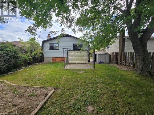 Expansive backyard featuring a mature tree, concrete patio area, and a garden bed - 99 Cluthe Crescent, Kitchener, ON 