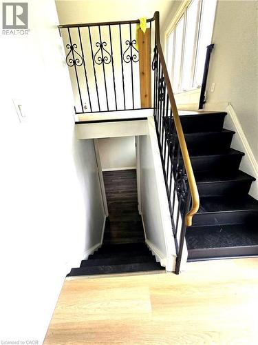 Black finished staircase with ornate black metal railing and wood-finish handrail - 99 Cluthe Crescent, Kitchener, ON 