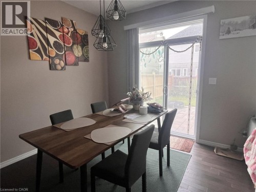 Sliding glass door leading to outdoor space, dark wood-finish flooring, and a contemporary multi-bulb light fixture - 298 Buttonbush Street, Waterloo, ON 
