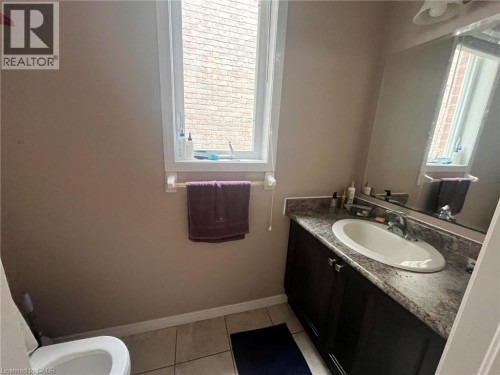 Recessed vanity with an integrated oval sink, a wall-mounted mirror, tile flooring, and an operable window - 298 Buttonbush Street, Waterloo, ON 