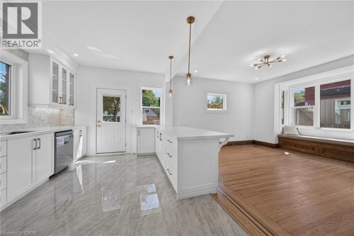 Kitchen featuring white cabinetry, a large center island, and stainless steel appliances - 229 Park Row S, Hamilton, ON 