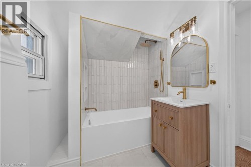 Contemporary bathroom featuring a light wood-finish vanity with a white countertop and gold-tone fixtures - 229 Park Row S, Hamilton, ON 