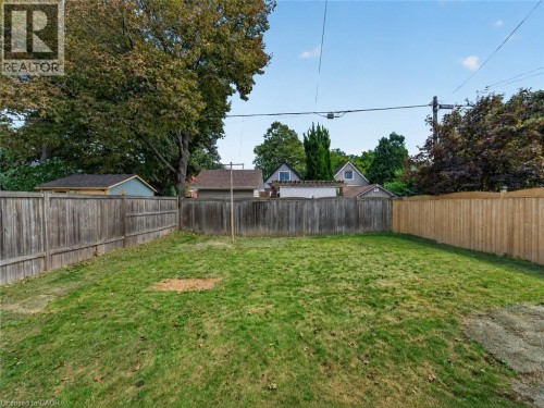Expansive grassy yard area featuring wood fencing - 229 Park Row S, Hamilton, ON 