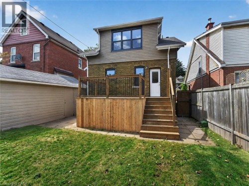 Expansive wood deck with stairs, featuring black metal railings and a privacy fence - 229 Park Row S, Hamilton, ON 