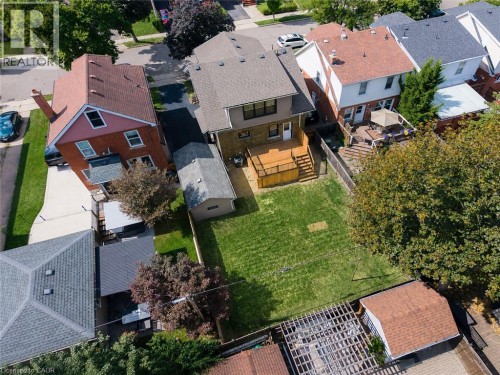 Expansive green lawn, multi-level wood deck, detached garage, and paved driveway - 229 Park Row S, Hamilton, ON 