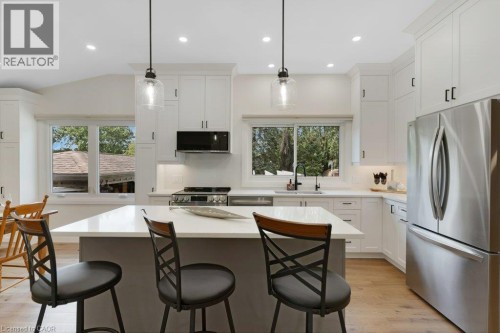 Kitchen featuring white shaker cabinetry, stainless steel appliances, a white island with pendant lighting, recessed lighting, and wood-finish flooring - 196 Abraham Street, Cambridge, ON 
