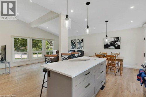 Vaulted ceiling with exposed beam, recessed lighting, wood-finish flooring, central island with countertop, and modern pendant lighting - 196 Abraham Street, Cambridge, ON 