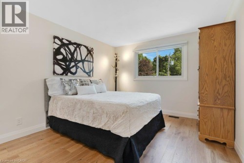Wood-finish flooring with white baseboards, light-colored walls, and a window with a natural backdrop - 196 Abraham Street, Cambridge, ON 