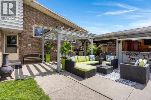 Expansive concrete patio with a white pergola structure and a built-in outdoor bar - 196 Abraham Street, Cambridge, ON 