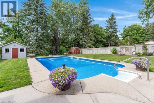 In-ground swimming pool with concrete surround, featuring a built-in step and handrail - 196 Abraham Street, Cambridge, ON 