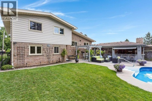 Expansive backyard featuring a manicured lawn, a swimming pool, and a dedicated patio space - 196 Abraham Street, Cambridge, ON 