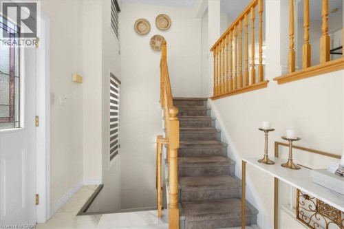 Staircase with wood banister and carpeted treads - 150 Bankside Drive, Kitchener, ON 