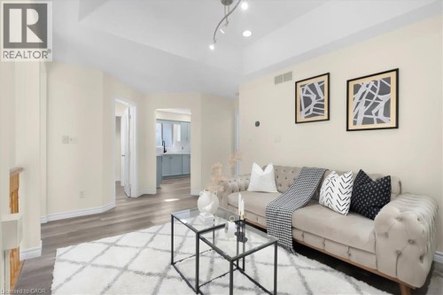 Bright, open living space featuring wood-finish flooring, recessed ceiling lighting, and track lighting - 150 Bankside Drive, Kitchener, ON 