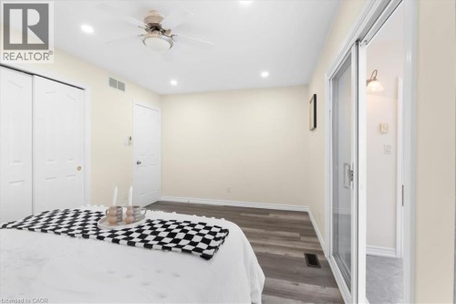 Wood-finish flooring, recessed lighting, ceiling fan, and sliding glass door - 150 Bankside Drive, Kitchener, ON 