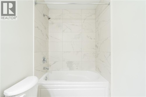 White bathtub with chrome fixtures and polished chrome shower rod - 23 Dryden Lane, Hamilton, ON 