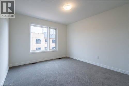 Neutral paint palette, wall-to-wall carpeting, and a flush mount ceiling light fixture - 23 Dryden Lane, Hamilton, ON 