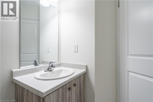 Vanity with a light-toned countertop and an integrated oval sink - 23 Dryden Lane, Hamilton, ON 