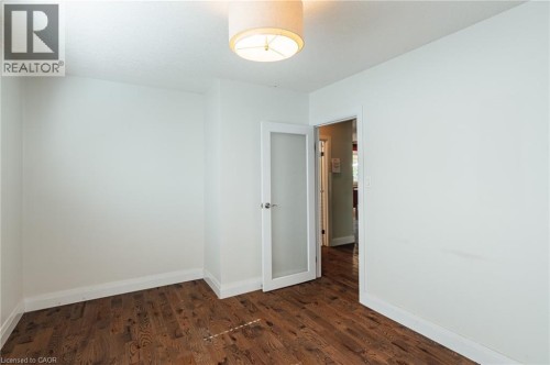 Wood-finish flooring, white walls, frosted glass panel door, and flush mount ceiling light fixture - 229 Winfield Avenue, Waterloo, ON 