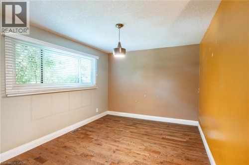 Wood-finish flooring, white window blinds, and a contemporary pendant light fixture - 229 Winfield Avenue, Waterloo, ON 