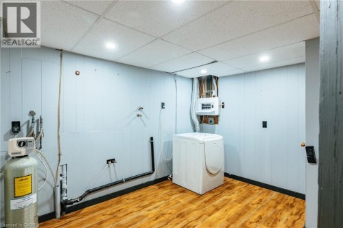 Laundry area with wood-finish flooring, recessed ceiling lighting, and panel walls - 229 Winfield Avenue, Waterloo, ON 