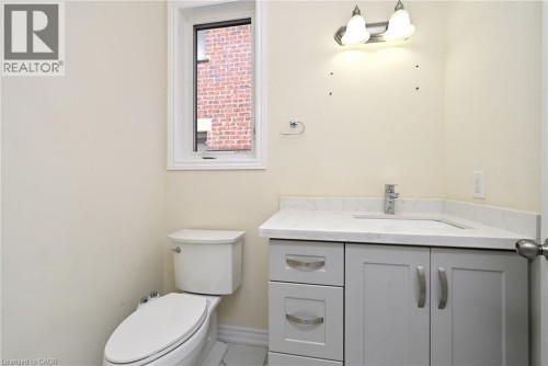 Corner vanity with stone-finish countertop and integrated sink, chrome faucet, and gray cabinetry with brushed nickel hardware - 64 Maple Cider Street, Caledon, ON 
