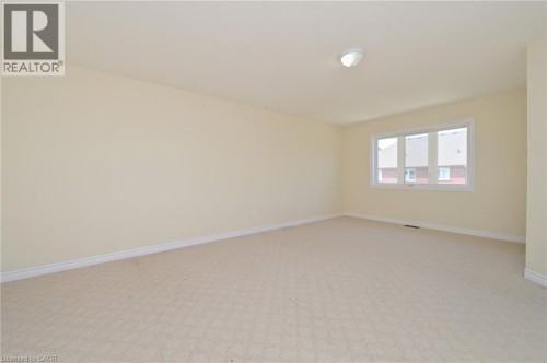 Carpeted flooring, neutral wall tones, triple window unit, and ceiling-mounted light fixture - 64 Maple Cider Street, Caledon, ON 