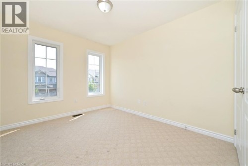 Recessed lighting, light-toned carpeting, and two paneled windows with white trim - 64 Maple Cider Street, Caledon, ON 