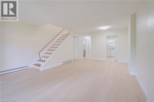 Light wood-finish flooring throughout,  flush-mount ceiling light fixtures, clean welcoming space. - 150 Westcourt Place, Waterloo, ON 